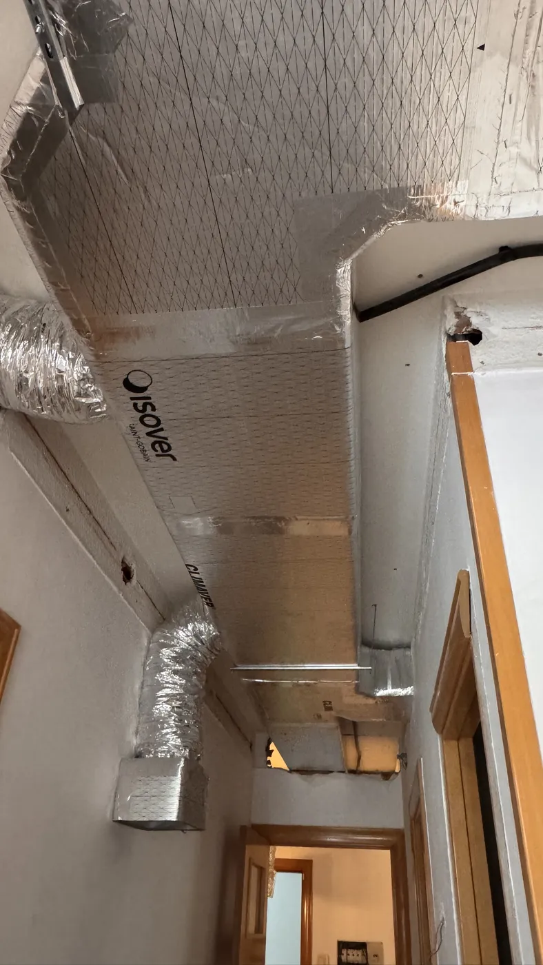 Conducto con salidas flexibles en pasillo de vivienda